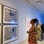 Exhibition visitors looking at Abdulnasser Gharem’s “Men at Work” series